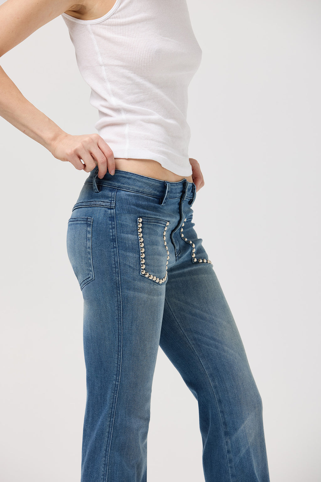 Studded patch pocket detail on mid-rise flare jeans