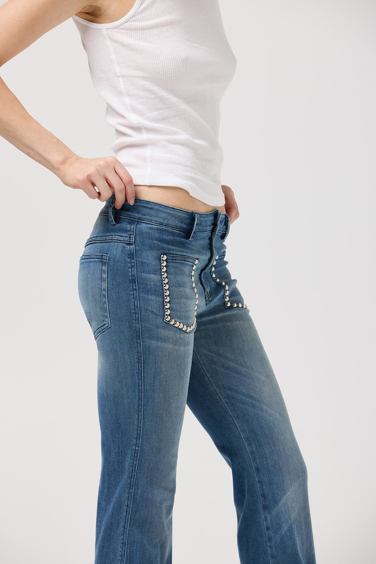 Studded patch pocket detail on mid-rise flare jeans